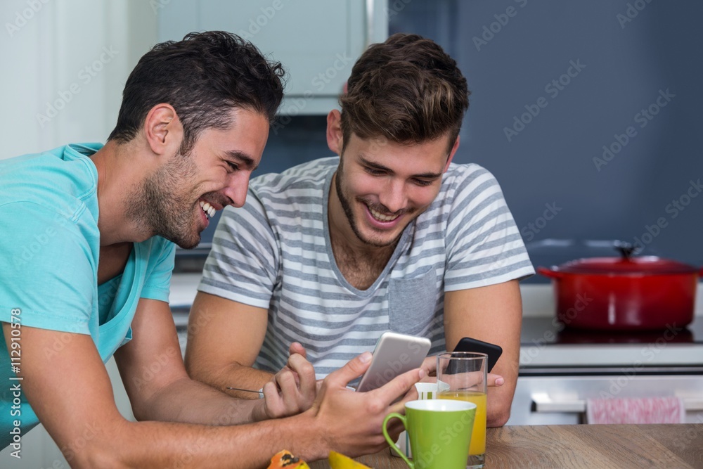 Cheerful male friends using phone Cheerful male friends using phone