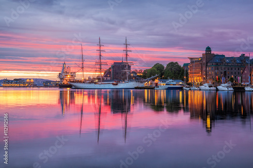 Old harbor with sail boat against sunset in Bergen. UNESCO World Heritage Site, Norway