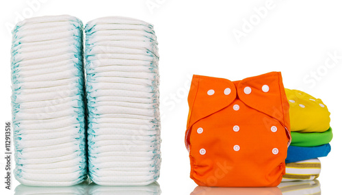 Stacks of disposable and cloth diapers modern isolated on white. photo