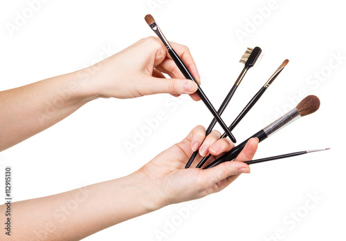Women hand with cosmetic brushes for makeup isolated on white.
