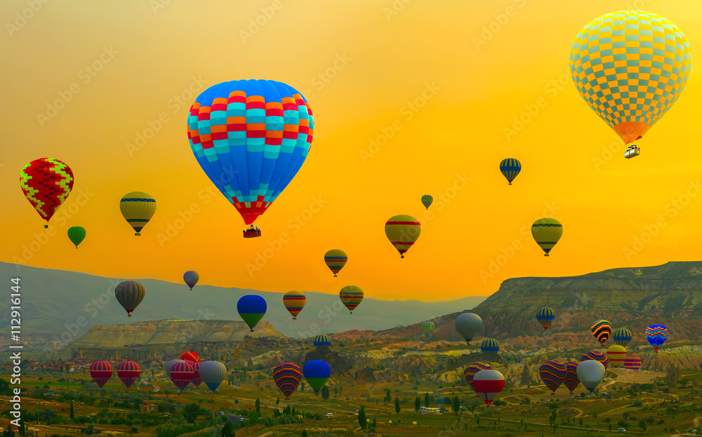 Obraz premium Hot air balloon over yellow landing in a mountain