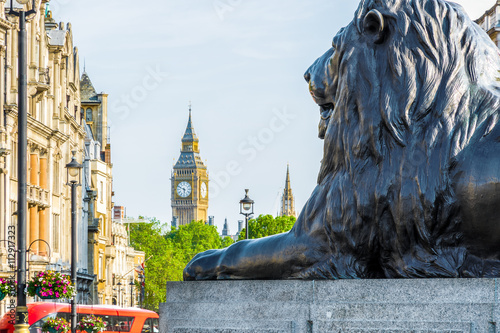 Lion sculpture at the base of Nelson’s Column in Trafalgar Square with Big Ben in the background