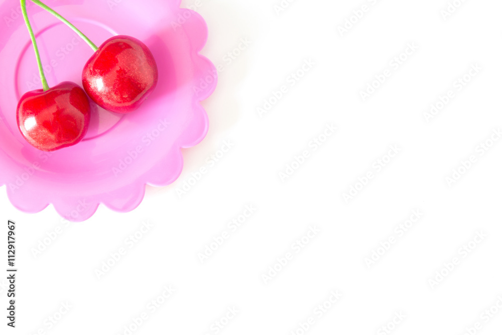 Fototapeta premium Cherry on a bright saucer isolated white
