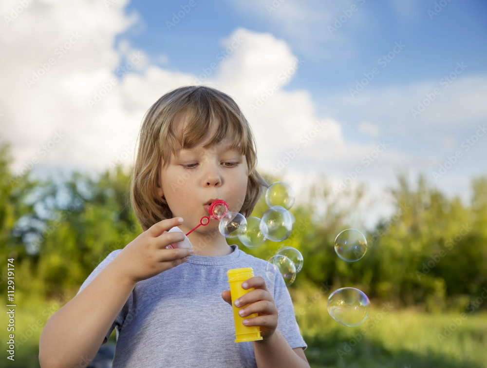 happy boy play in bubbles outdoors