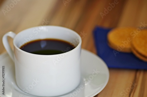 Coffee. Cup of coffee and chocolate cookies on rustic wooden table. Black coffee for breakfast. Hot drinks.