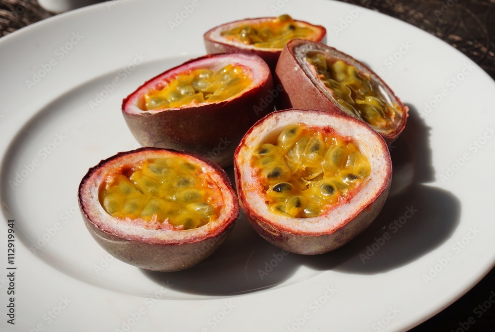 A plate of juicy passion fruit cut in half A plate of juicy passion fruit cut in half