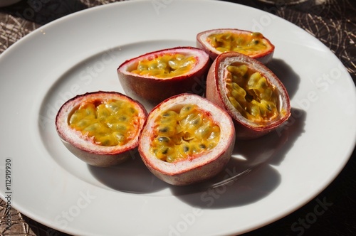 A plate of juicy passion fruit cut in half photo