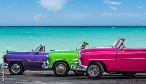 Drei amerikanische Oldtimer am Strand von Havanna Kuba