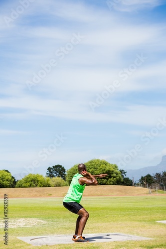 Male athlete preparing to throw shot put ball