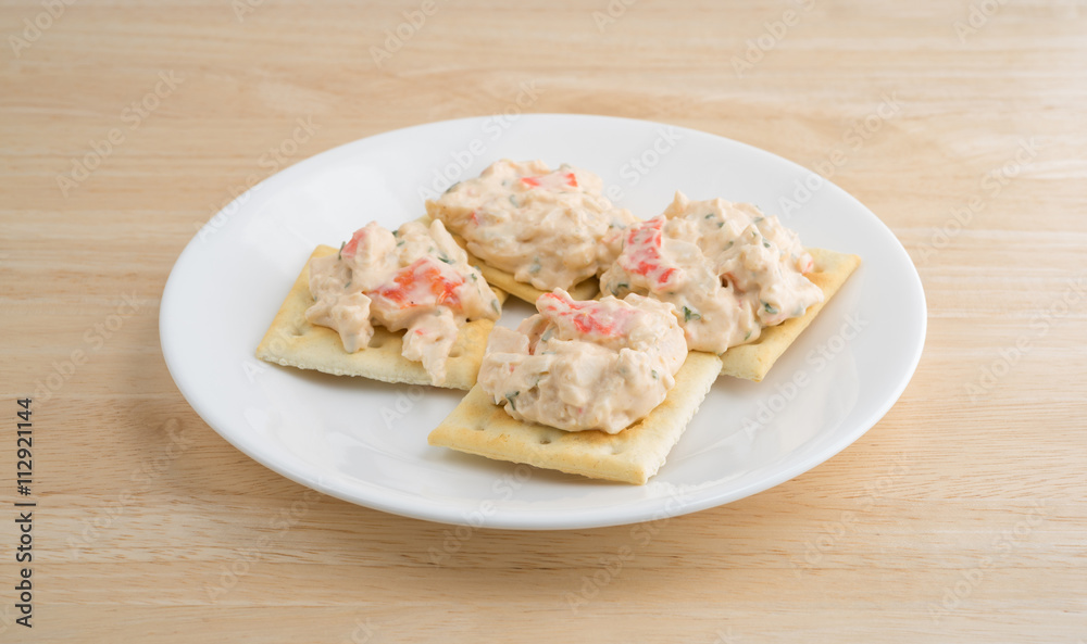 Plate of lobster dip on saltine crackers on a wood table. Plate of lobster dip on saltine crackers on a wood table.