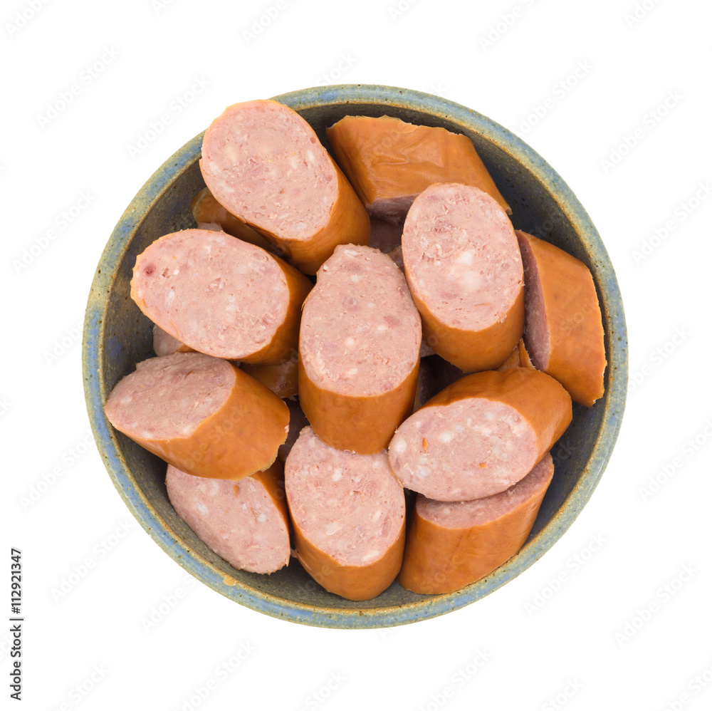 Reduced calorie kielbasa sausage slices in a bowl top view isolated on