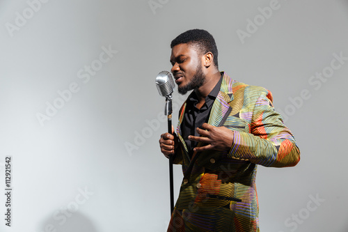 Afro amerian man singing into vintage microphone photo