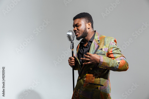 Afro amerian man singing into vintage microphone