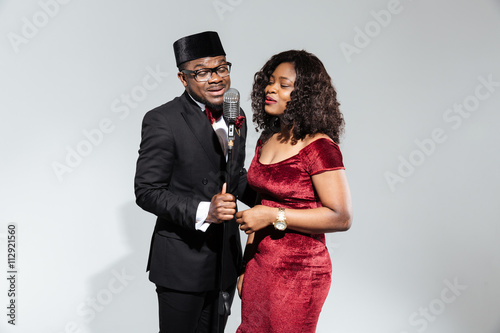 Canvas Print Couple singing into vintage microphone