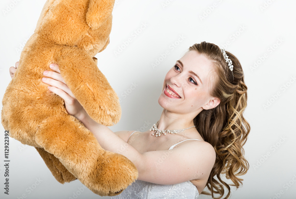 young beautiful bride holding a teddy bear, they gently hug young beautiful bride holding a teddy bear, they gently hug