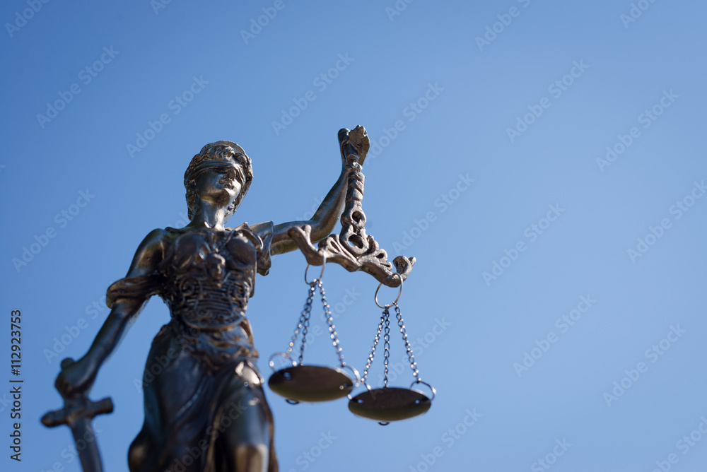 sculpture of themis, femida or justice goddess on bright blue sky background