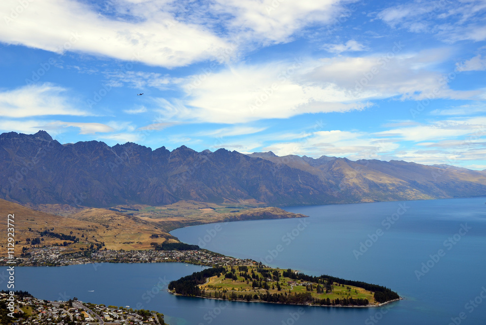Obraz premium Scenic view of Queenstown and surrounding rugged mountain range (The Remarkables) on the shores of the glacial Lake Wakatipu, New Zealand