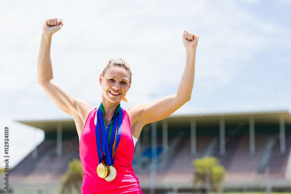 Excited female athlete with gold medals around her neck Excited female athlete with gold medals around her neck