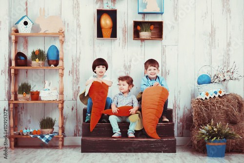 Three beautiful laughing little children in the spring Easter interior photo Studio