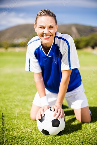 Female football player kneeling on field with ball © WavebreakmediaMicro