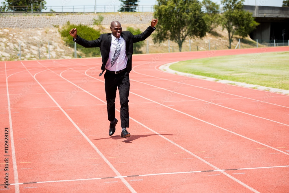 Excited businessman standing on the running track Excited businessman standing on the running track