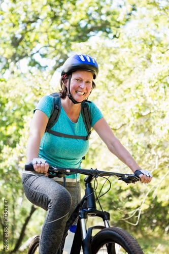 Mature woman smiling and riding bike