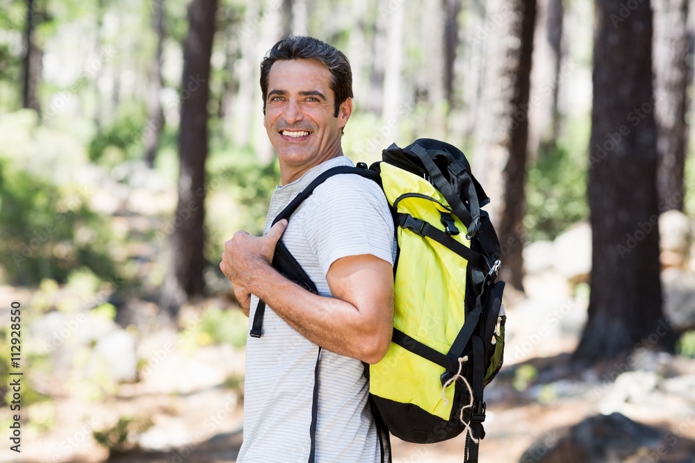 Naklejka premium Man smiling and posing with his backpack