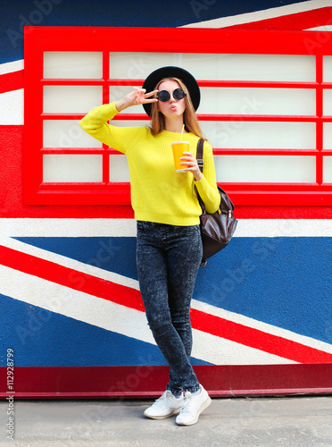 Fashion pretty woman with cup having fun over colorful backgroun