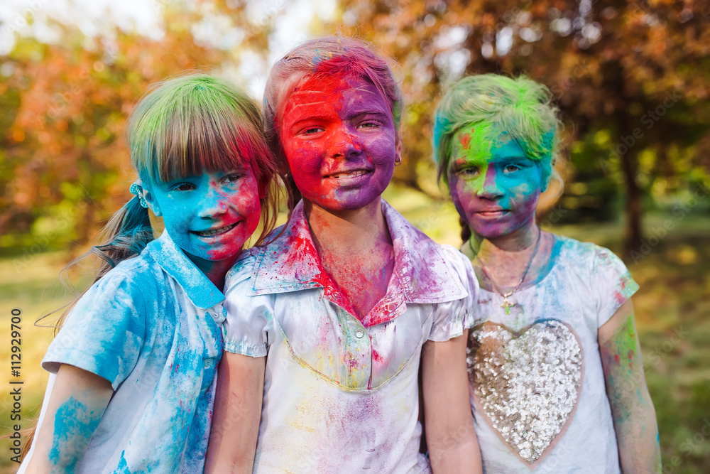 cute european child girls celebrate Indian holi festival with co