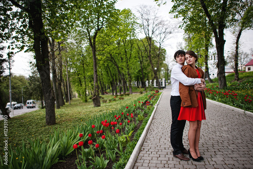 Couple hugging in love at path with tulip flowers garden. Stylis © AS Photo Family