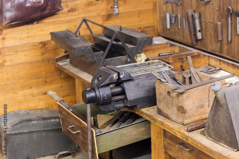 Old workshop with workbench, vise and other hand tools. Open dra Old workshop with workbench, vise and other hand tools. Open dra