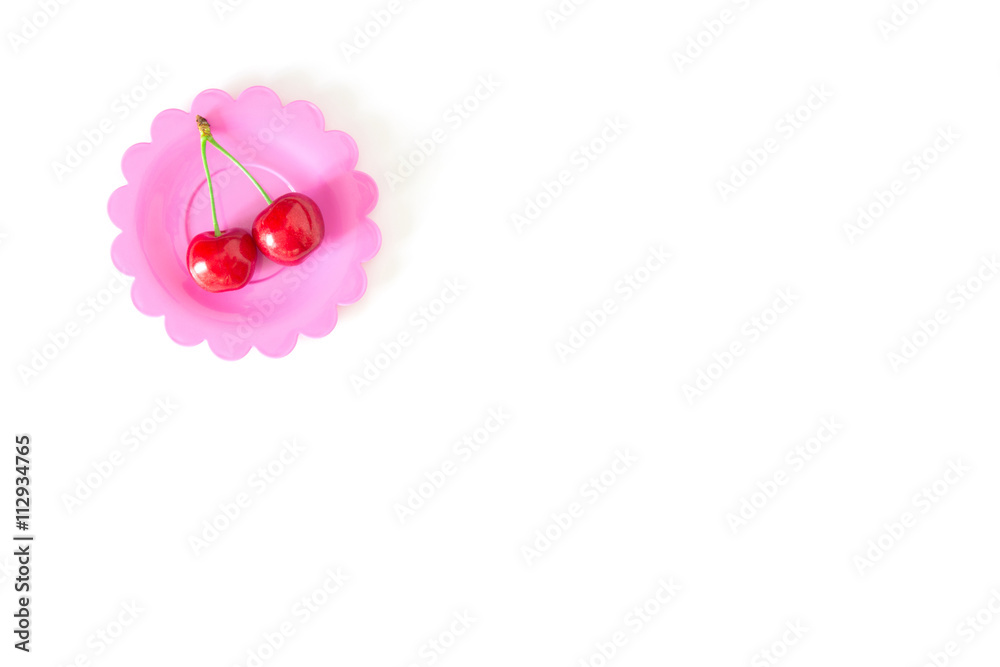 Cherry on a bright saucer isolated white