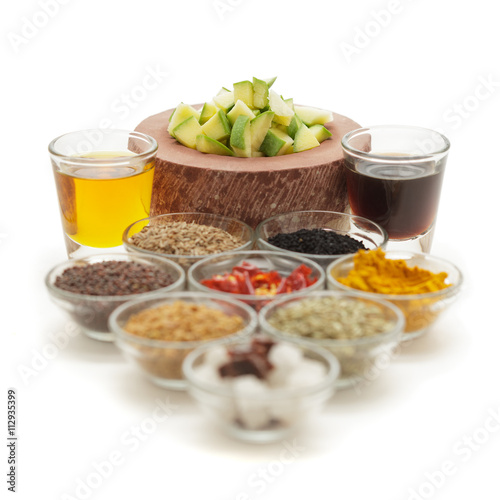 Raw ingredients for Indian mango pickle in glass bowls isolated on white background. 