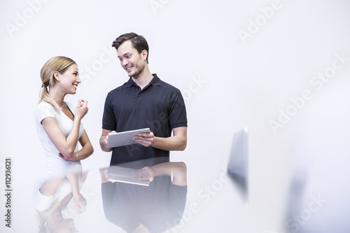 Dentist talking to patient , holding digital tablet