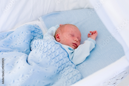 Fotografie Newborn baby boy in white bassinet