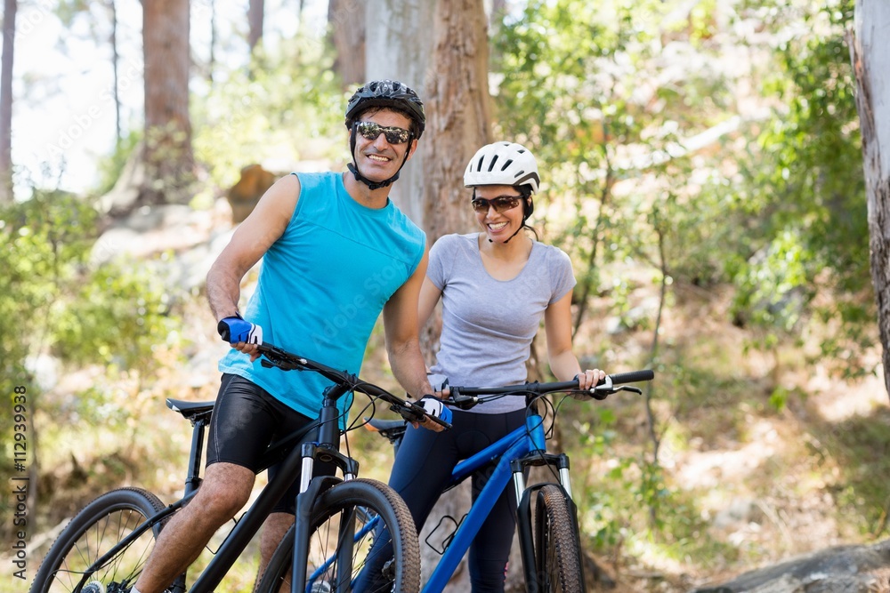 Couple smiling and posing with their bikes 
