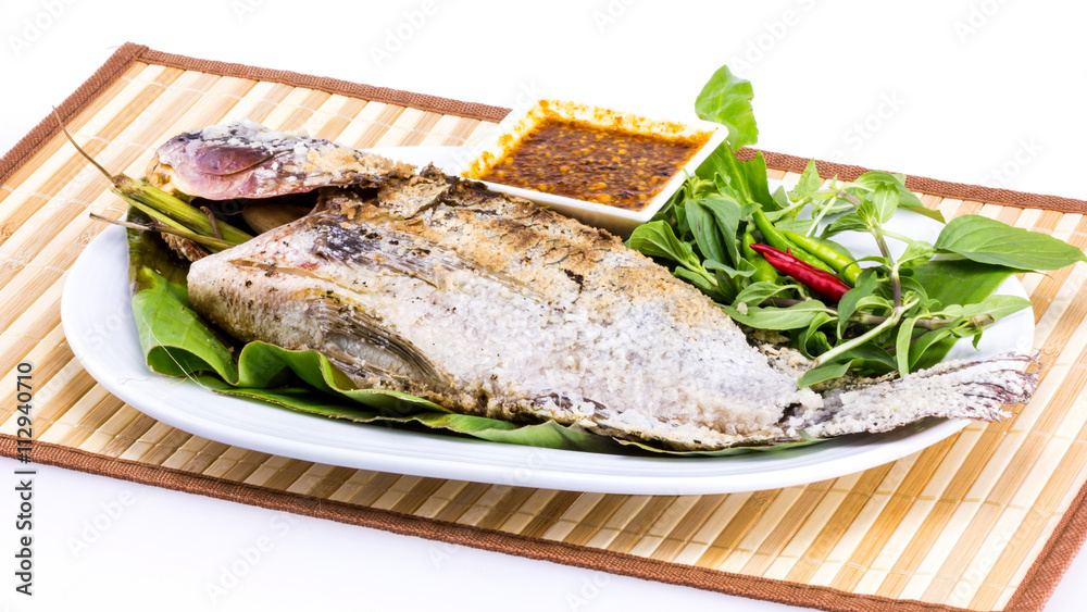 Grilled fish with salt on white plate