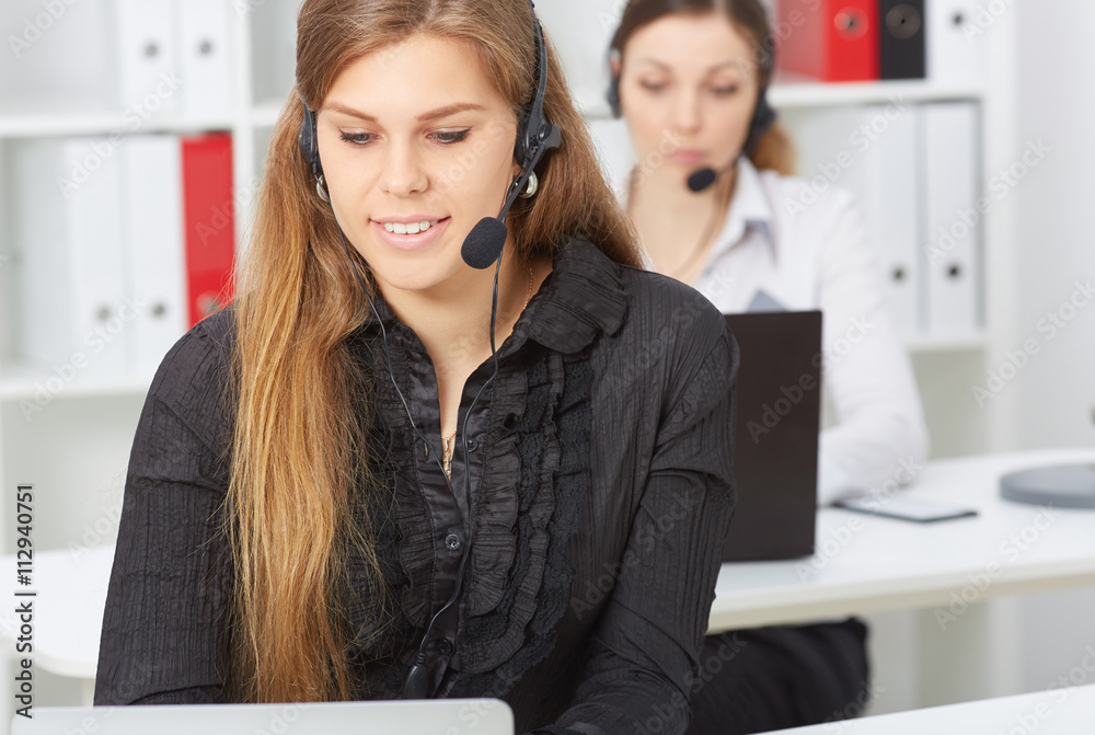 Female call center service operator at work. Portrait of smiling pretty female helpdesk employee with headset at workplace. Effective and efficient business information, help and support concept Female call center service operator at work. Portrait of smiling pretty female helpdesk employee with headset at workplace. Effective and efficient business information, help and support concept