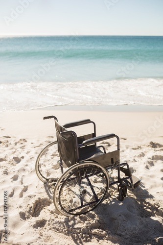 Black wheelchair on the beach on a sunny day