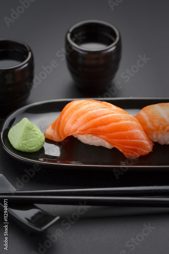 Japanese cuisine. Sushi roll with soy sauce over black background.