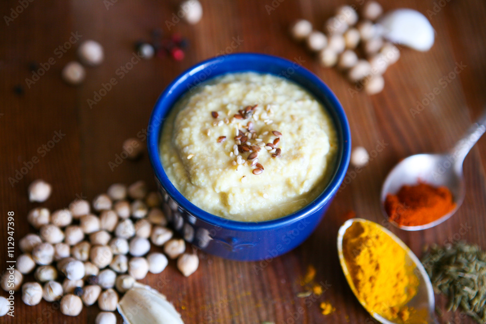 Hummus, chickpea dip, with rosemary, smoked paprika and olive oil in an authentic bowl with pita on a wooden background. Hummus, chickpea dip, with rosemary, smoked paprika and olive oil in an authentic bowl with pita on a wooden background.