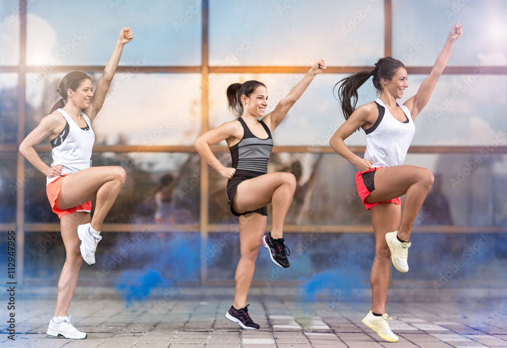 Three smiling girls doing aerobic exercises outside Three smiling girls doing aerobic exercises outside