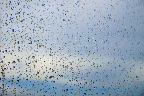 Rain / Water drop of rain on glass window with blue sky outdoor