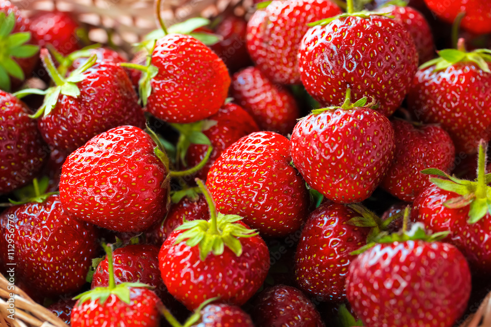 Very beautiful background with fresh strawberries in a wicker heart shaped wickerwork basket Very beautiful background with fresh strawberries in a wicker heart shaped wickerwork basket