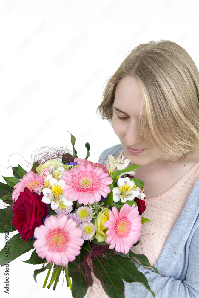 Blondes Mädchen schnuppert an einem Blumenstrauss