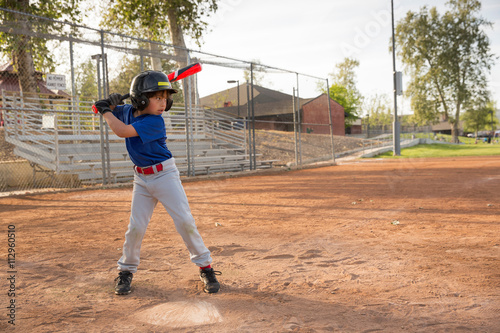 Boy batting at practise on baseball field