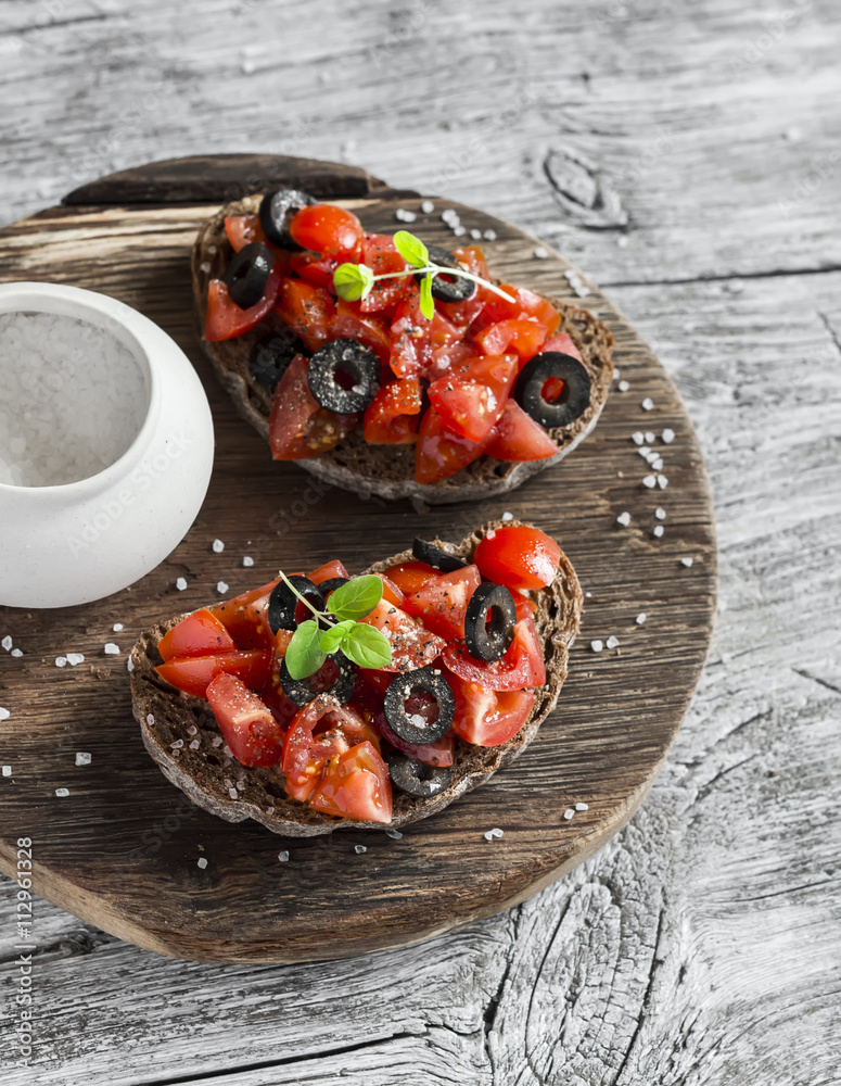 Tomatoes and olives bruschetta  on rustic wooden background