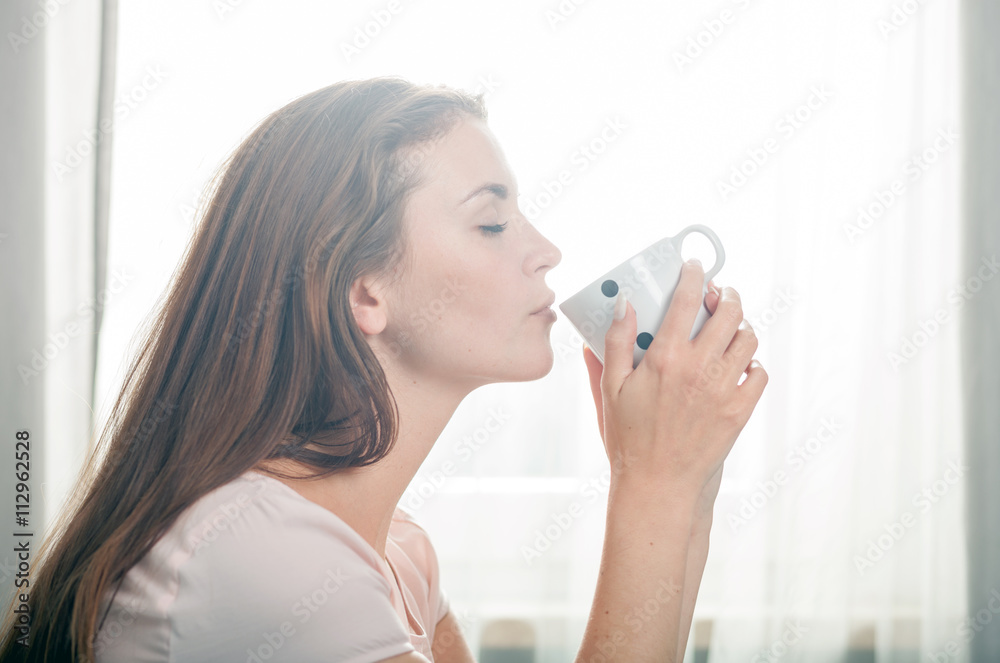 Portrait of young woman relaxing at home and drinking coffee. Casual style indoor shoot Portrait of young woman relaxing at home and drinking coffee. Casual style indoor shoot
