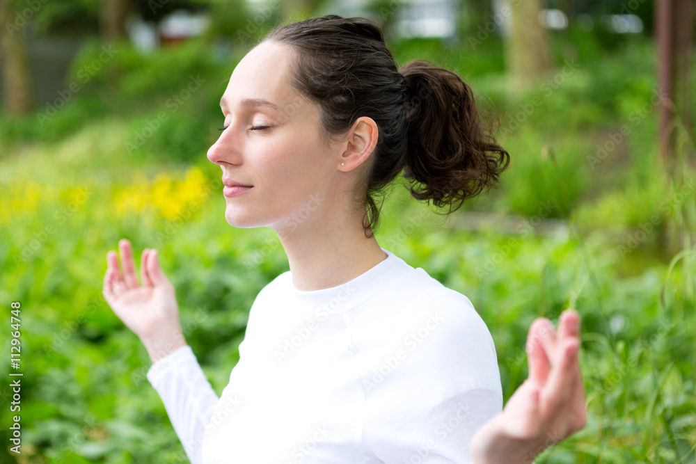 View of a Young attractive woman practising yoga in a park View of a Young attractive woman practising yoga in a park