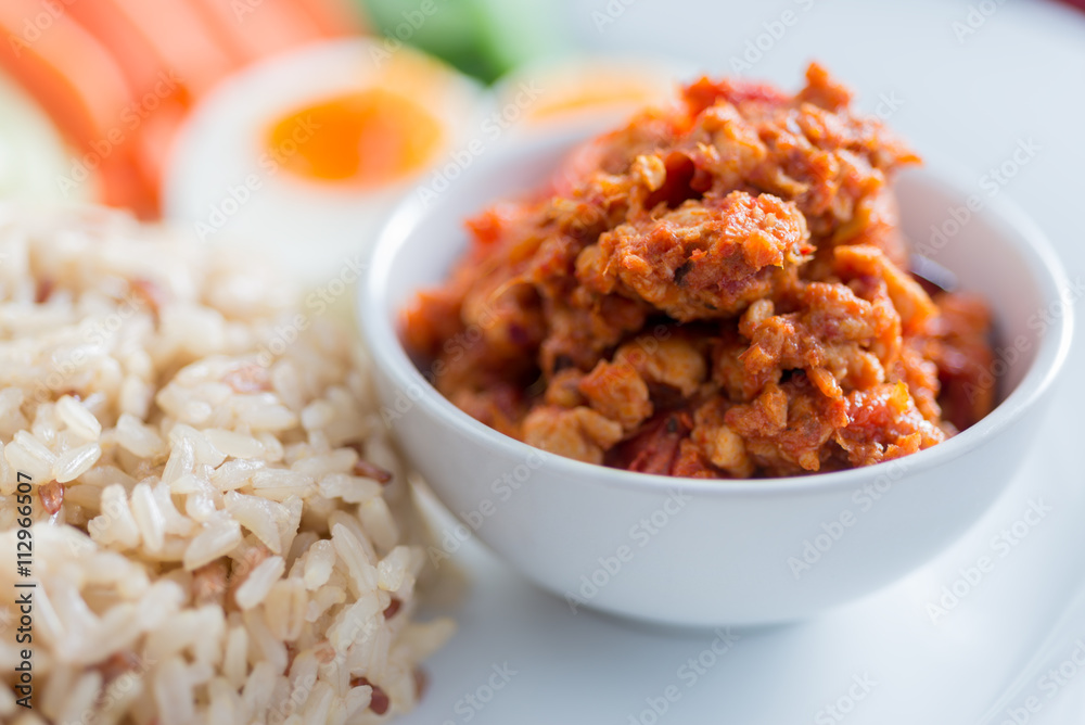 Foods series : Spicy chicken and tomato dip, served with brown rice, boiled egg and fresh vegetable, Thai foods, northern style, selective focus Foods series : Spicy chicken and tomato dip, served with brown rice, boiled egg and fresh vegetable, Thai foods, northern style, selective focus